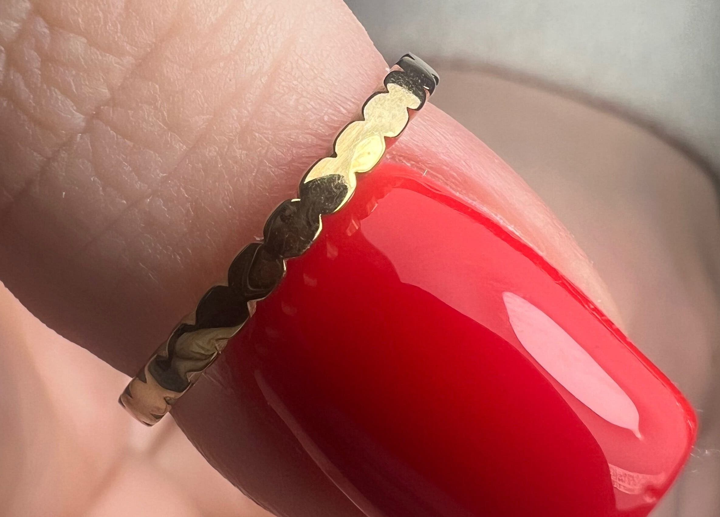 A detailed view of a textured gold ring on a manicured finger at Dangina Studio, Aurora, Illinois, US.