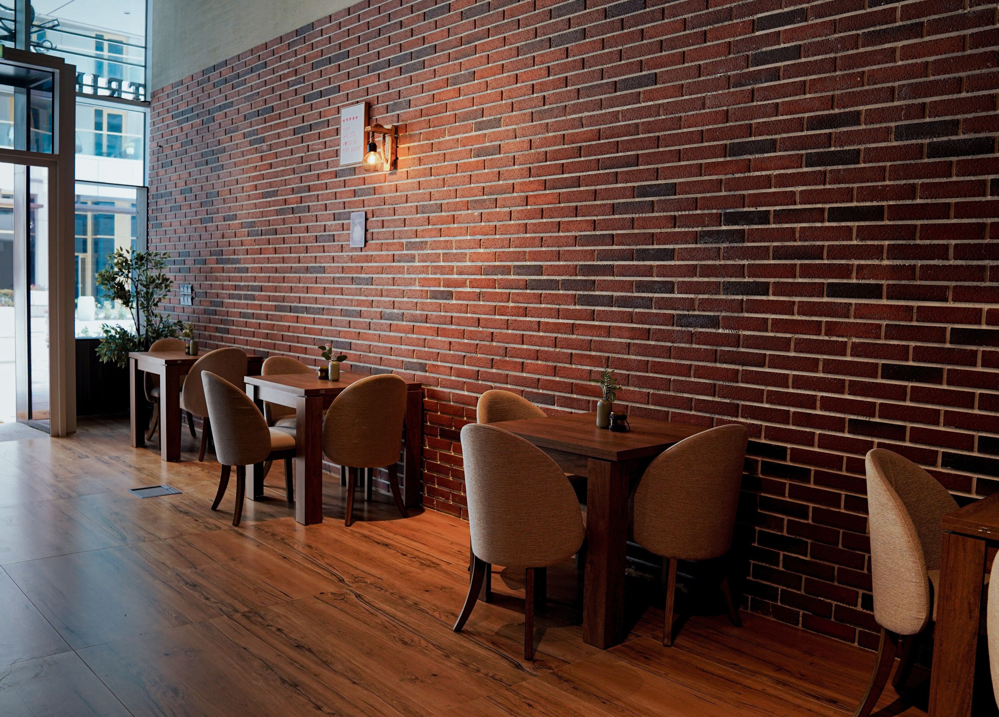 Cozy seating at Trim and Latte Men Hairdressing Trimming and Styling, Abu Dhabi with brick wall design.