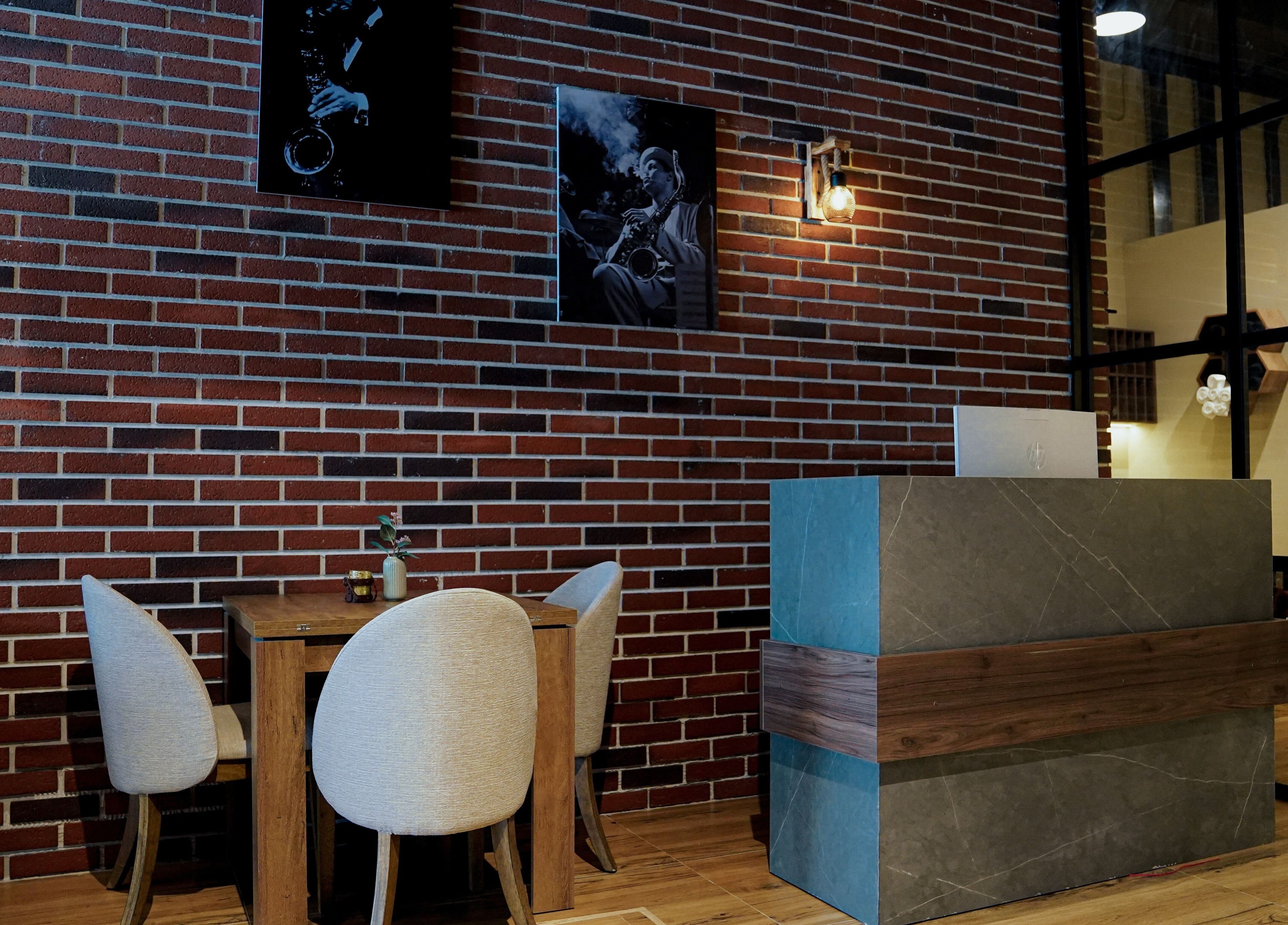 Reception area of Trim and Latte Men Hairdressing Trimming and Styling, Abu Dhabi featuring cozy seating and decor.