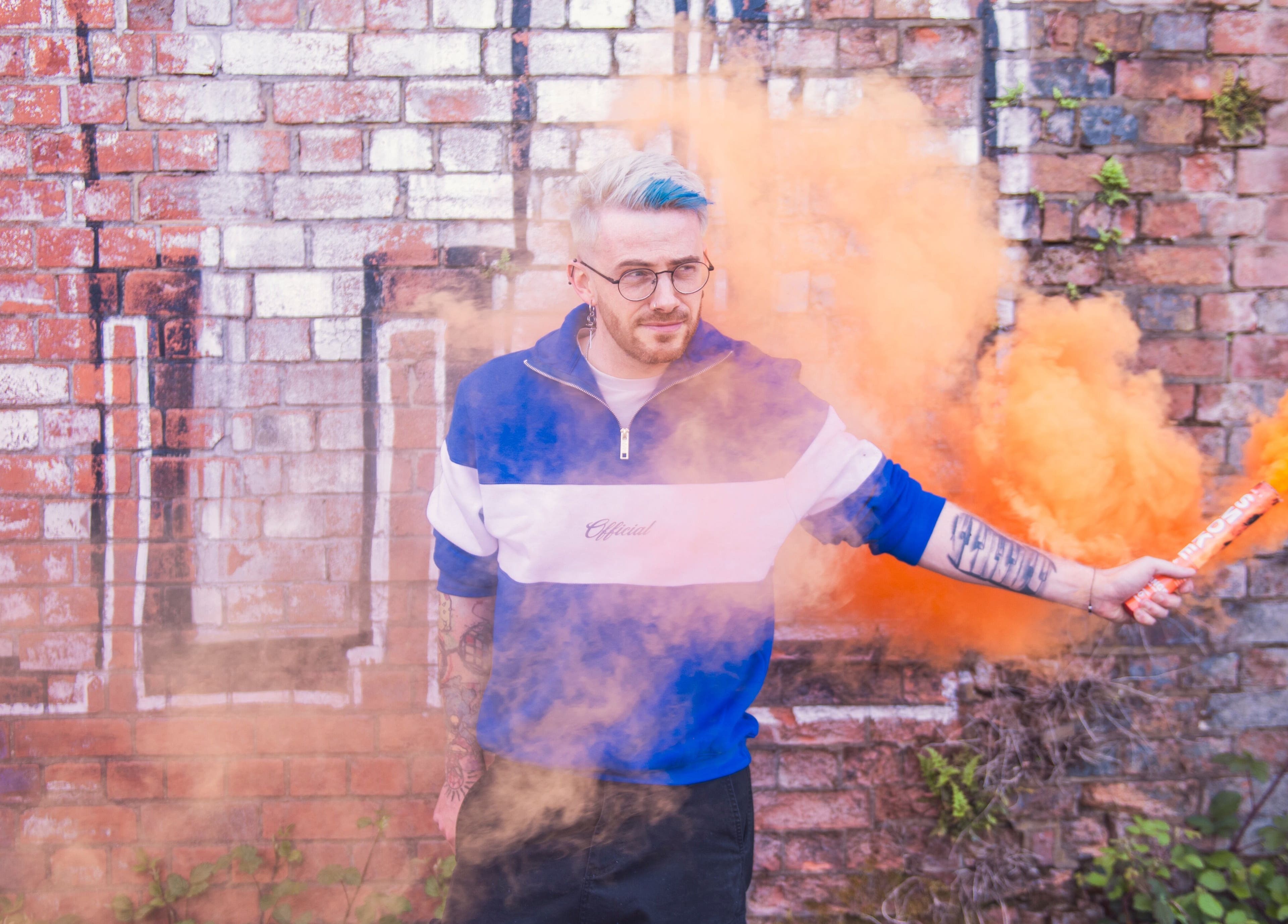 Man holding orange smoke outside Spendlow's Barbering, Newark-on-Trent, England, GB.