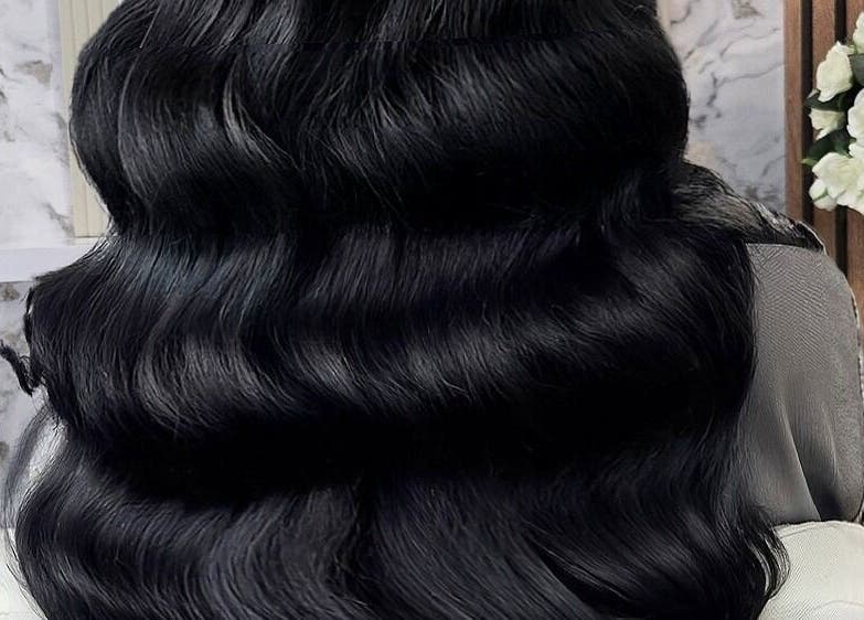 Lustrous black hair extensions at Deluxe Aurora Hair Extensions, Stoke-on-Trent, England, GB, exhibited in elegant waves.
