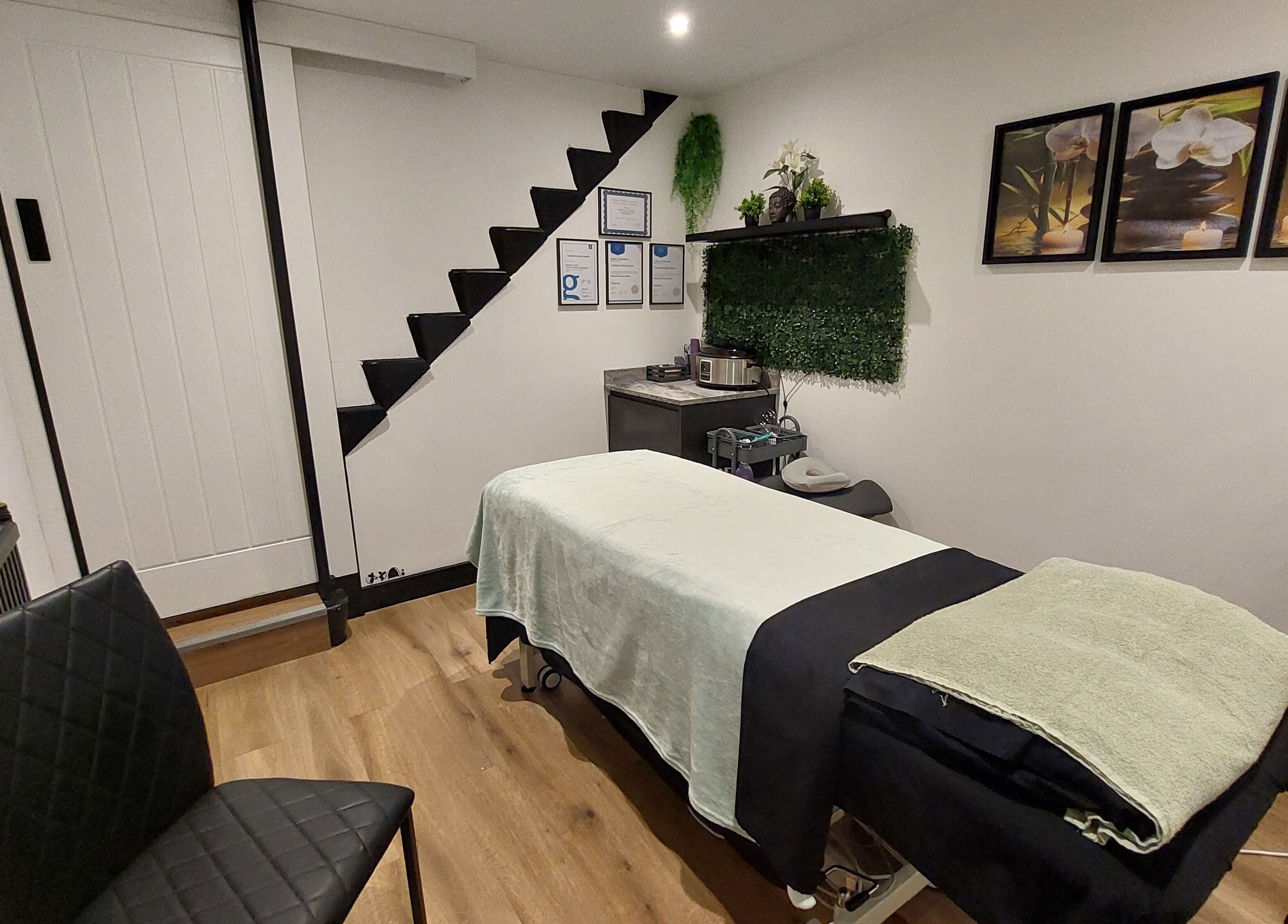Relaxing massage room at Tranquility Well-Being, Cromer, England, GB with decor and treatment table.