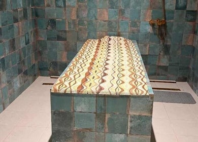 Elegant spa room at Noir Salon & Spa, Zinj, Muḥāfaẓat Al-ʿāṣimah, BH with a tiled massage table.