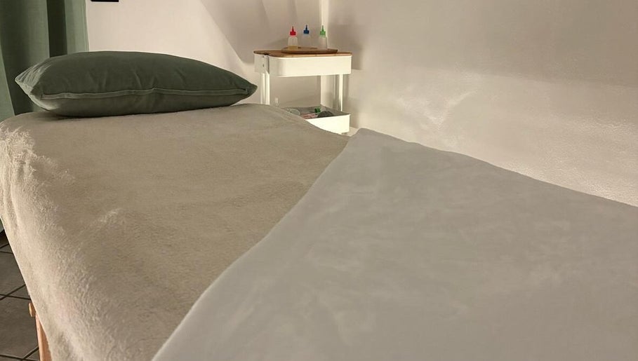 Stanza massaggio con letto e cuscino verde a Perla Holizen, Novara, Piemonte, IT.