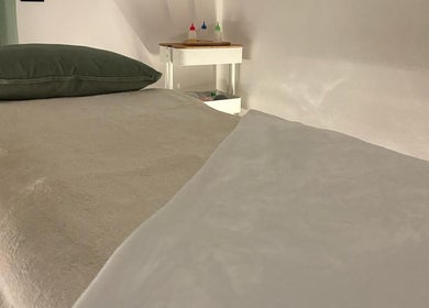 Stanza massaggio con letto e cuscino verde a Perla Holizen, Novara, Piemonte, IT.
