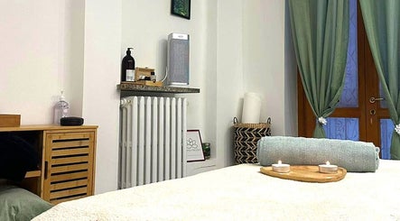 Stanza benessere di Perla Holizen, Novara, Piemonte, con candele accese e tessuti rilassanti.