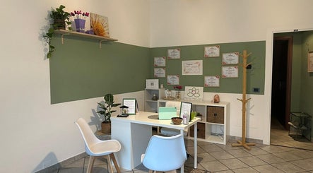 Reception accogliente di Perla Holizen a Novara, Piemonte, IT. Design moderno con piante e certificati.