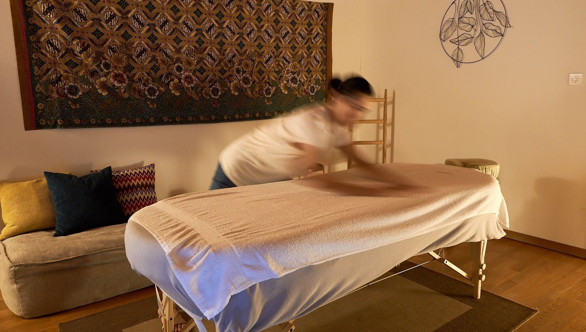 Massage paisible chez À Toi À Moi, Romanel-sur-Lausanne, Vaud, CH, sur table ornée de coussins colorés.