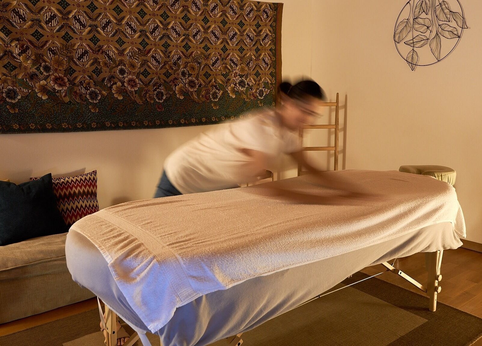 Massage paisible chez À Toi À Moi, Romanel-sur-Lausanne, Vaud, CH, sur table ornée de coussins colorés.