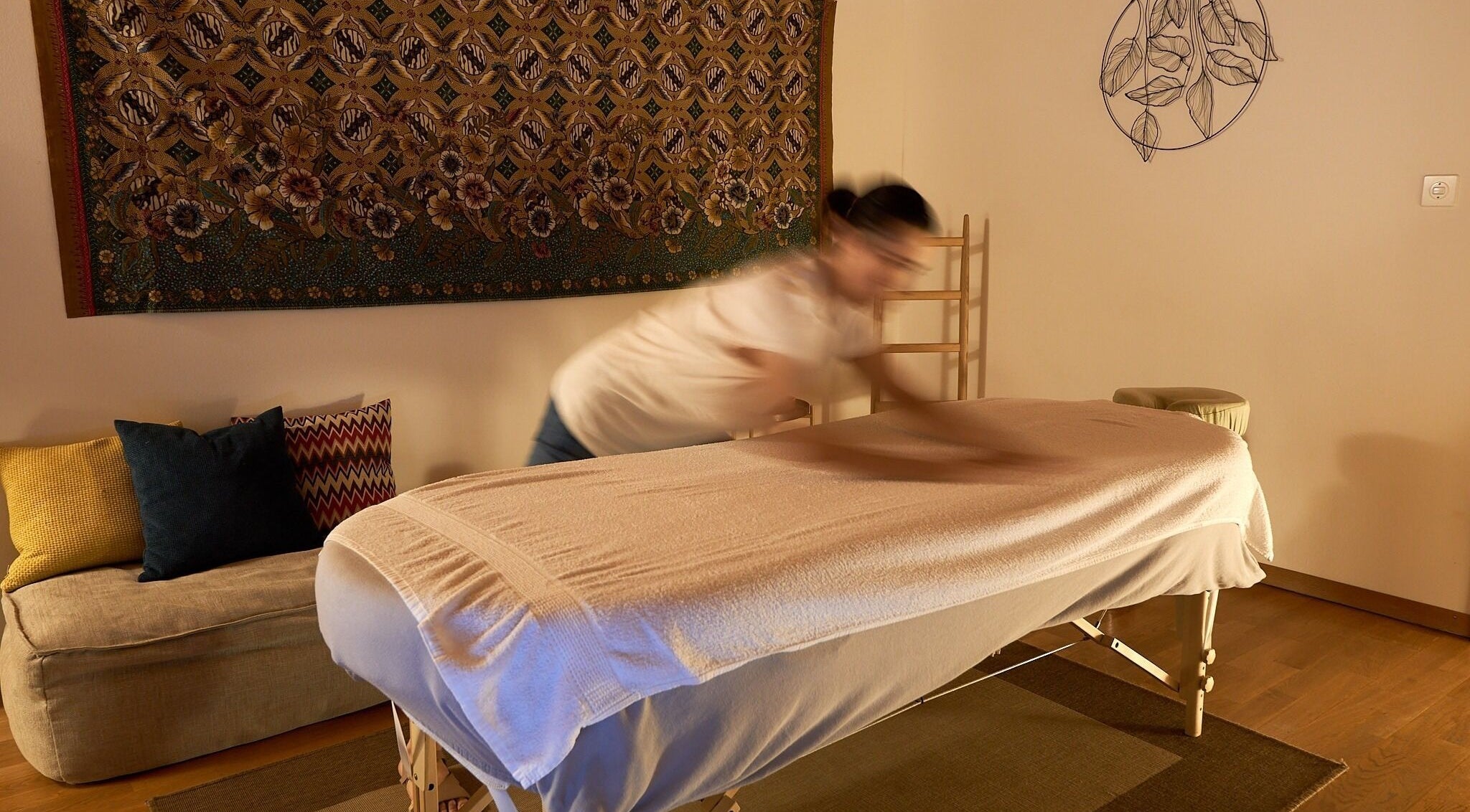 Massage paisible chez À Toi À Moi, Romanel-sur-Lausanne, Vaud, CH, sur table ornée de coussins colorés.