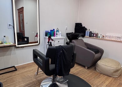 Cozy salon corner at Les Coupes de Mathieu, Montréal, Québec, CA with chair, mirror, and hair products.
