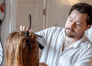 A stylist expertly cuts hair at Les Coupes de Mathieu in Montréal, Québec, CA.
