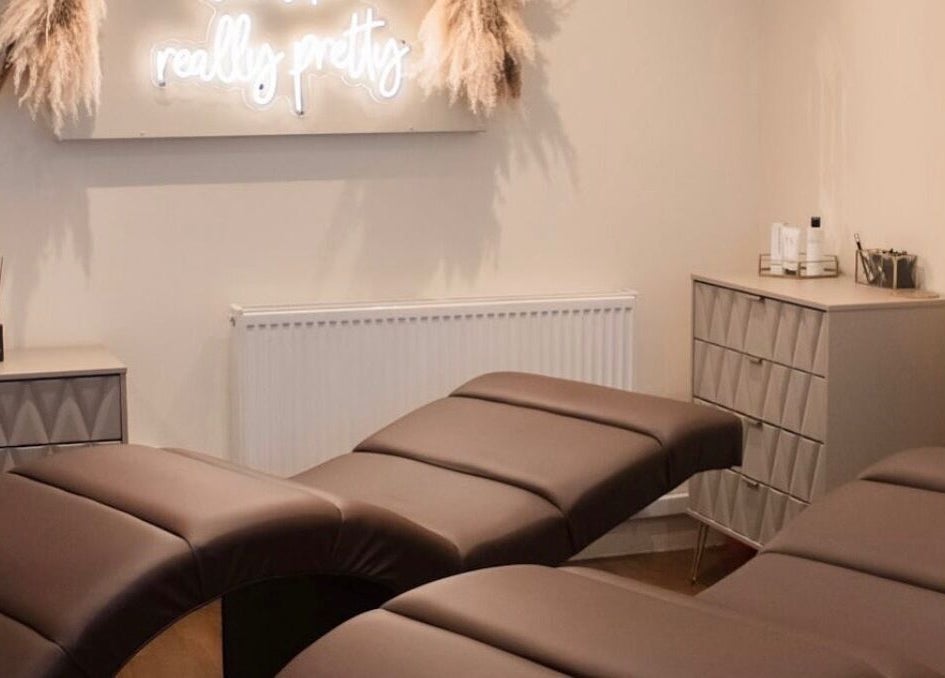 Relaxing treatment room at Gloss’d, Bangor, Wales, GB, featuring comfortable massage beds and calming decor.