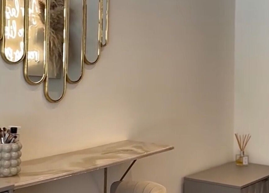 Chic vanity setup at Gloss’d, Bangor, Wales, GB featuring stylish mirror and makeup brushes.