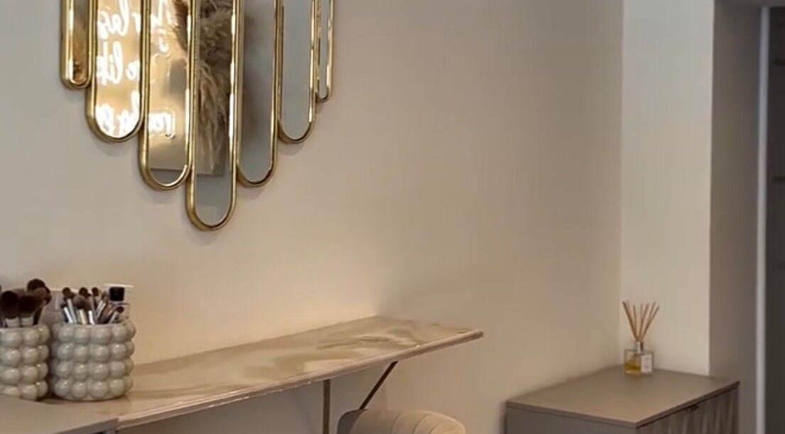 Chic vanity setup at Gloss’d, Bangor, Wales, GB featuring stylish mirror and makeup brushes.