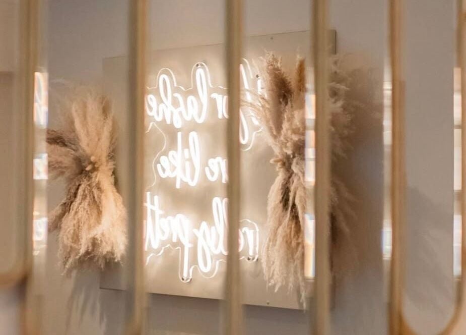 Chic neon sign reflection at Gloss’d in Bangor, Wales, GB, enhancing the salon's modern aesthetic.