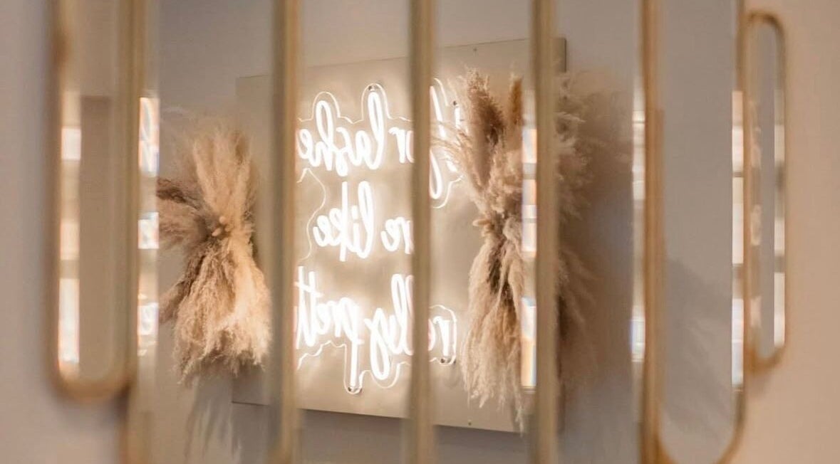 Chic neon sign reflection at Gloss’d in Bangor, Wales, GB, enhancing the salon's modern aesthetic.