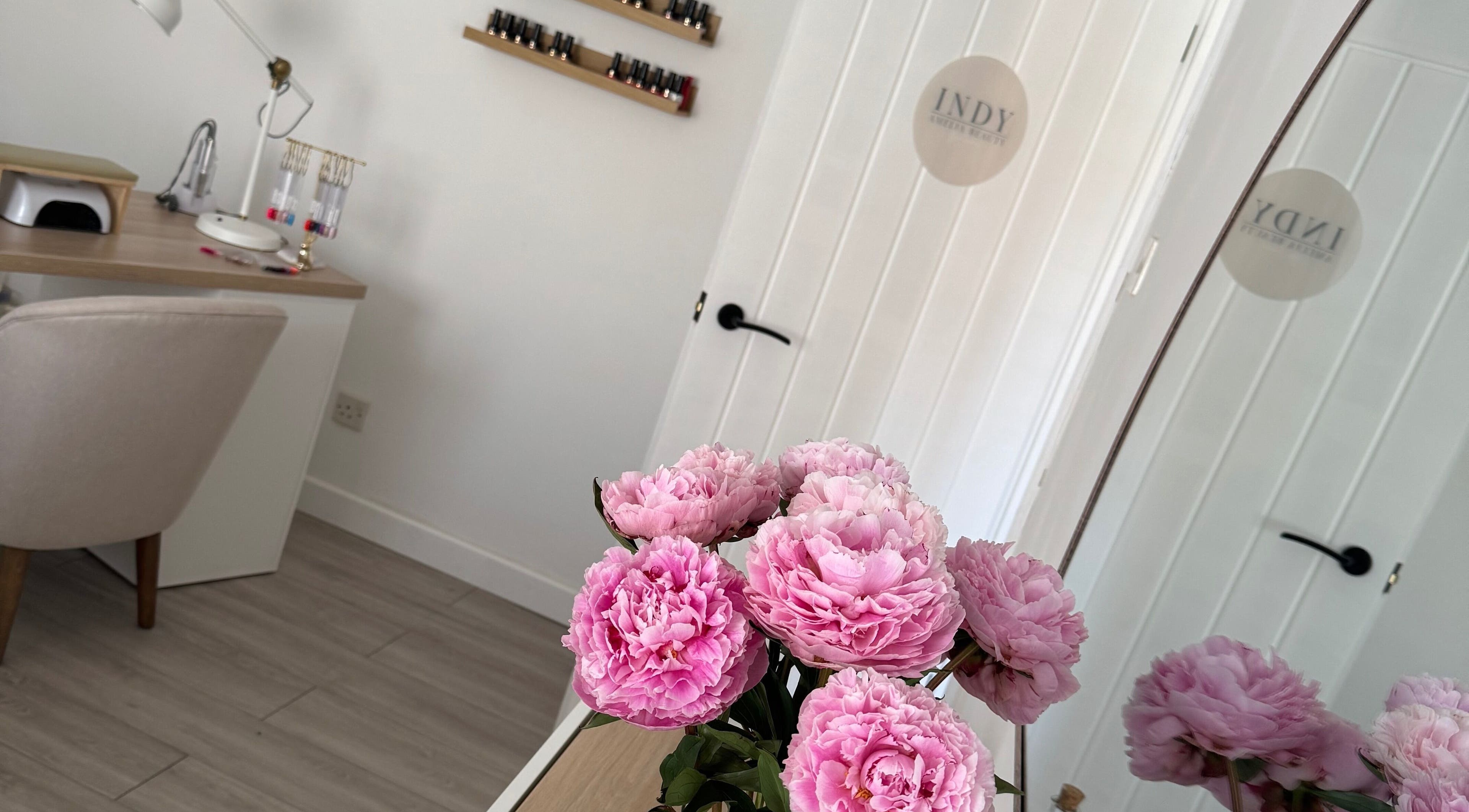 Indy Amelia Beauty in Stony Stratford, England features elegant pink flowers and a serene workspace.