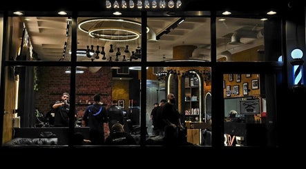 Warmly lit interior of Blade and Fade barbershop in Riyadh, Riyadh Province, SA, showcasing sleek decor.