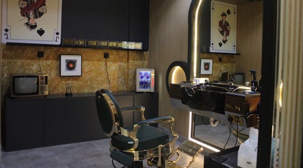 Vintage-inspired barber chair at Blade and Fade, Riyadh, Riyadh Province, SA. Unique decor with playing card art.
