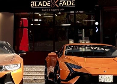Blade and Fade barbershop entrance with luxury cars parked in Riyadh, Riyadh Province, SA.