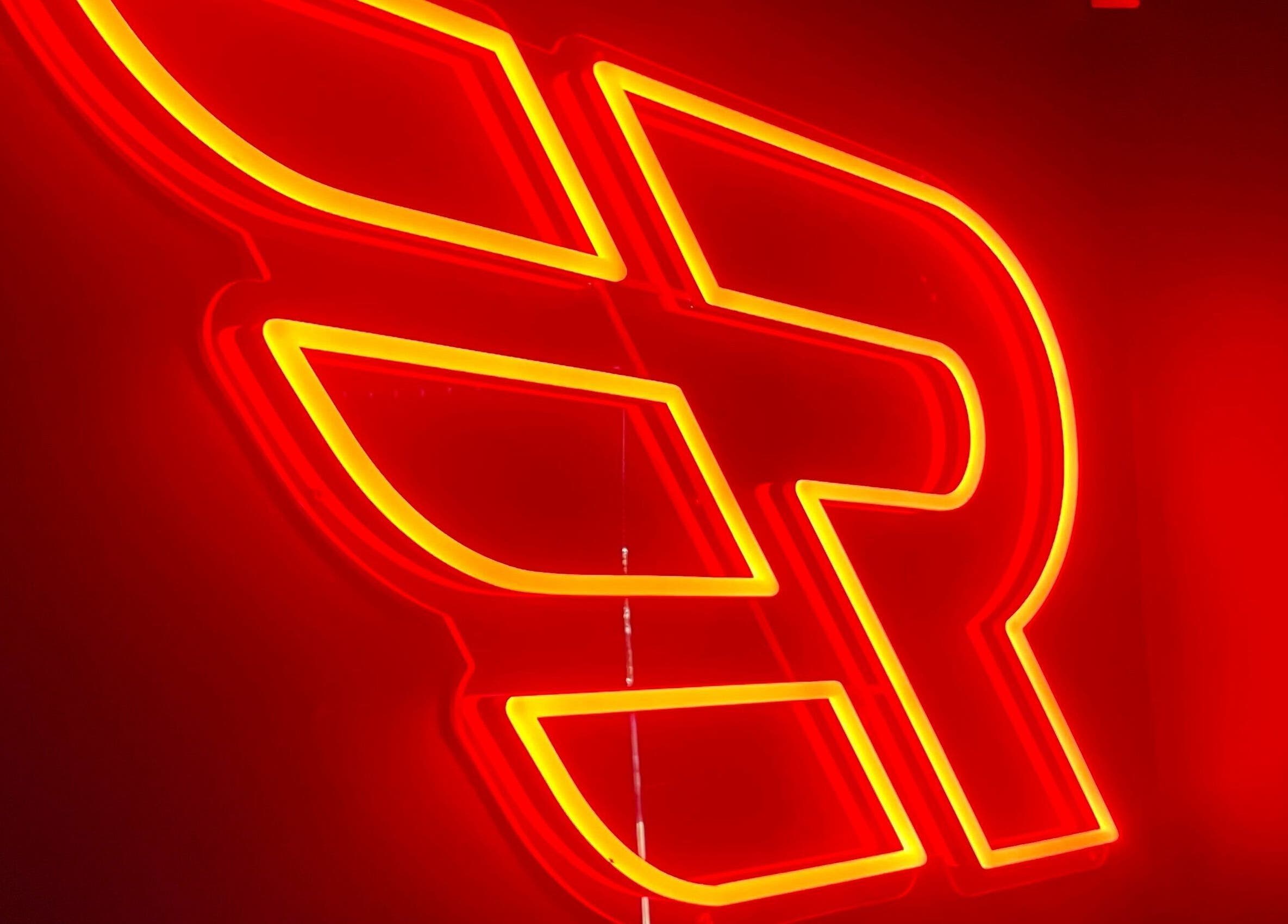 Neon sign at Engineroom Barbers in Fountaindale, New South Wales, AU, glowing in warm red and yellow hues.