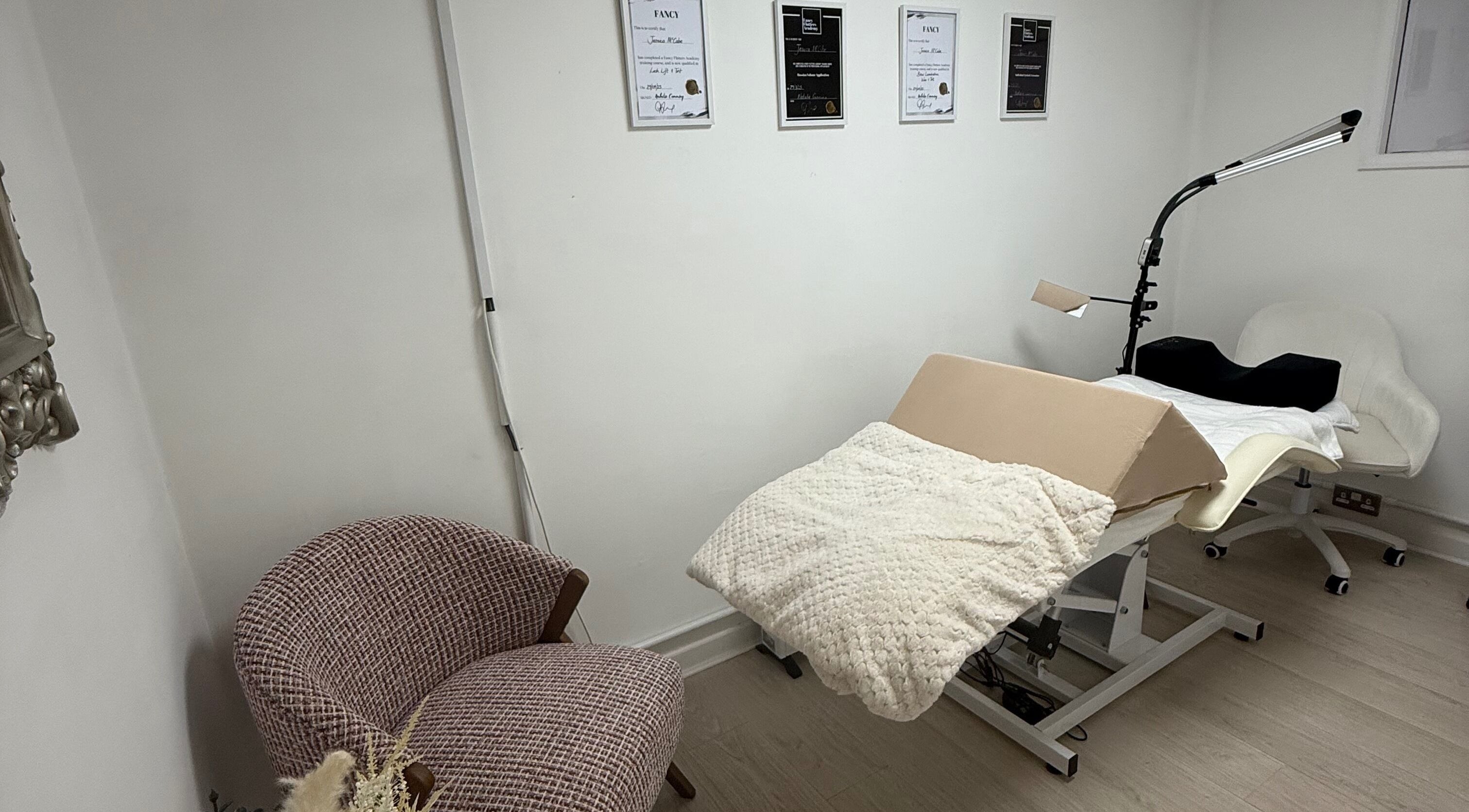 Calm treatment room at Lash Dreams By Jess, Motherwell, Scotland, GB, featuring cozy chair and therapy bed.