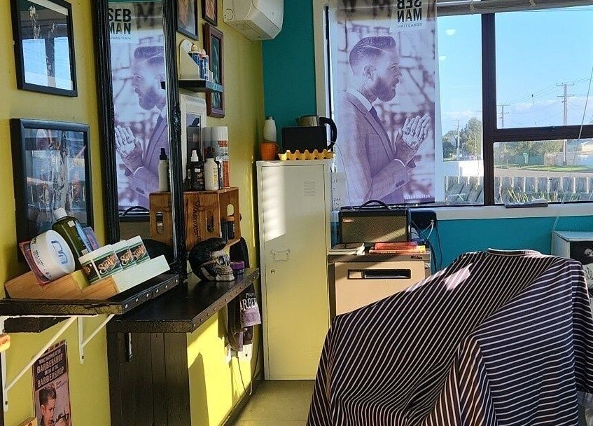 Inside The Salty Barber in Manawatū-whanganui, NZ, showcasing stylish barber chair and grooming products.