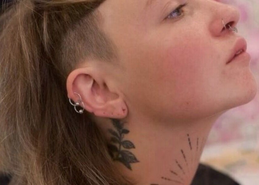 Stylish undercut and tattoo at The Salty Barber, Manawatū-whanganui, NZ, showcasing bold personal style.