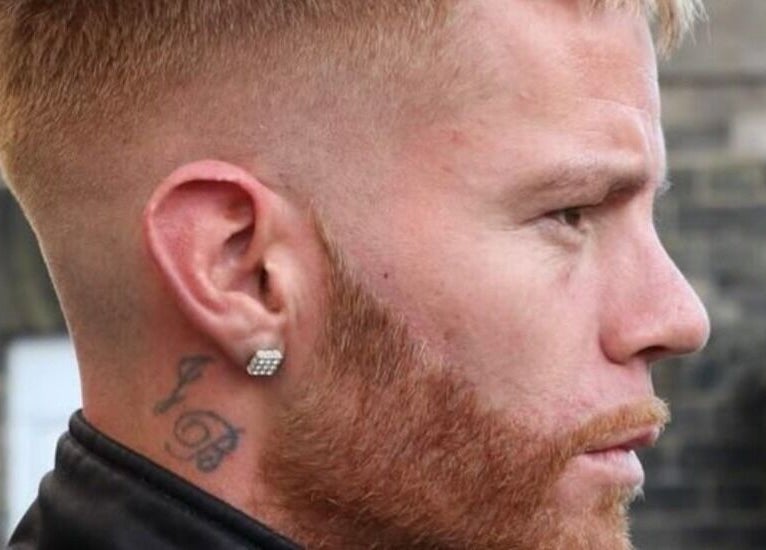 Close-up of stylish haircut and beard at The Salty Barber, Manawatū-whanganui, NZ. Urban brick background.