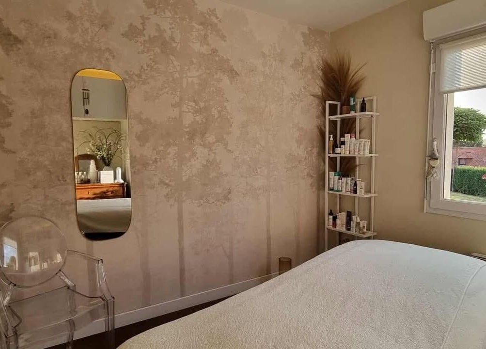 Salle de soin élégante chez Beauté Et Compagnie, Delettes, FR avec mur beige et miroir moderne.