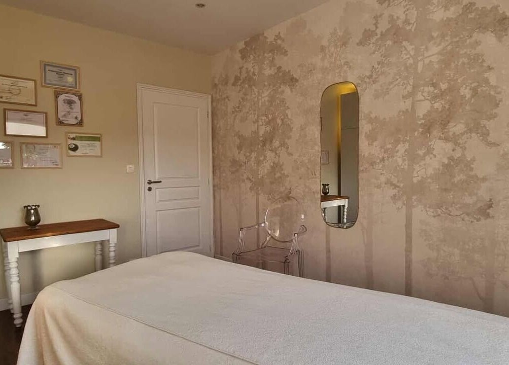 Salle de soins relaxante au Beauté Et Compagnie, Delettes, FR, avec décor mural apaisant.