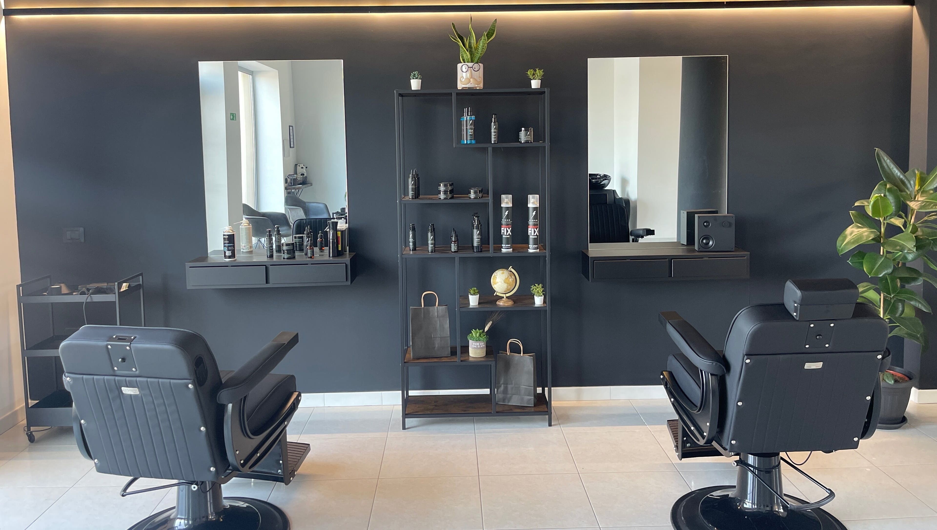 Interno elegante del salone STORM a Capurso, Puglia, IT, con sedie nere e scaffali di prodotti.