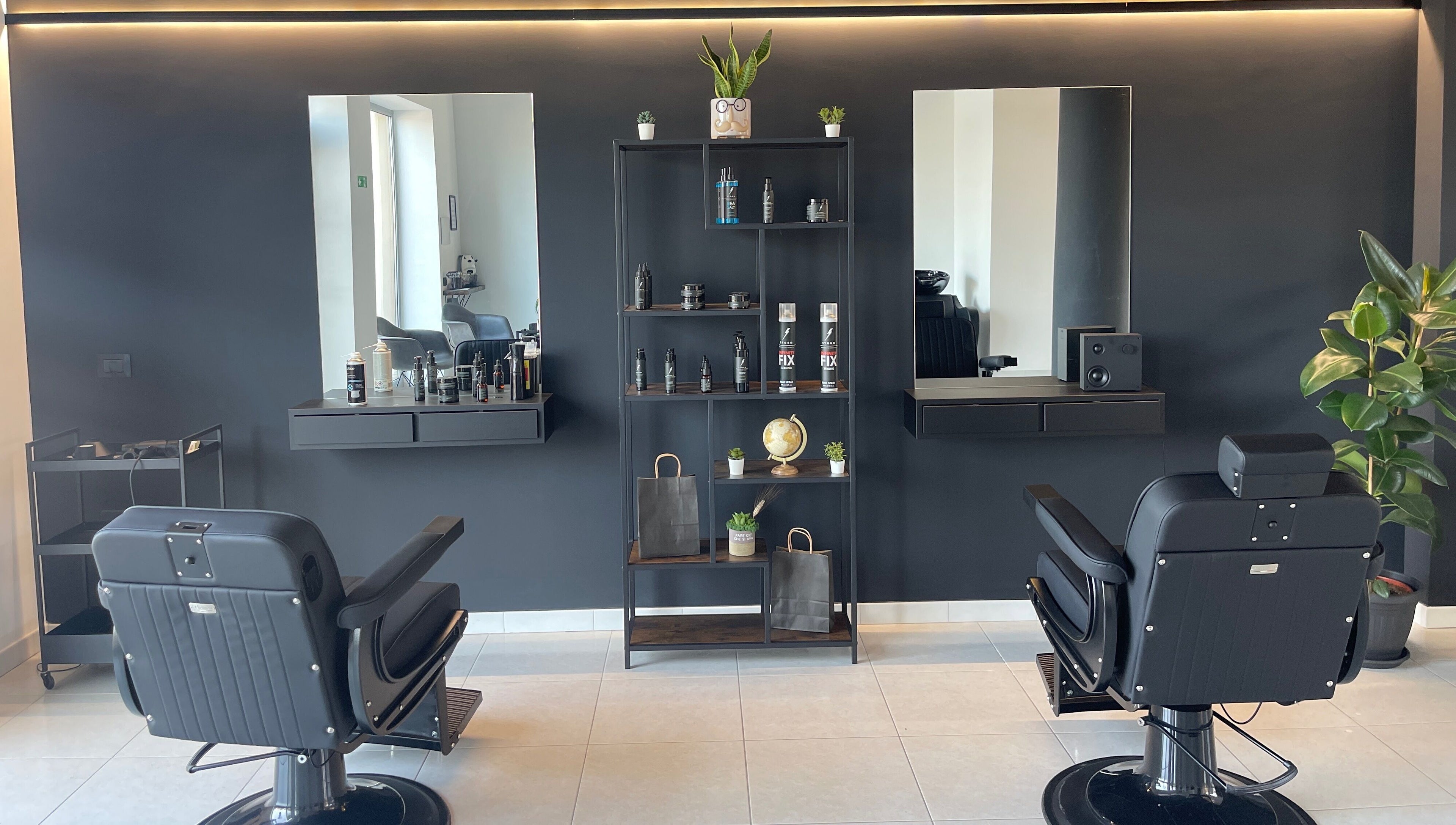 Interno elegante del salone STORM a Capurso, Puglia, IT, con sedie nere e scaffali di prodotti.