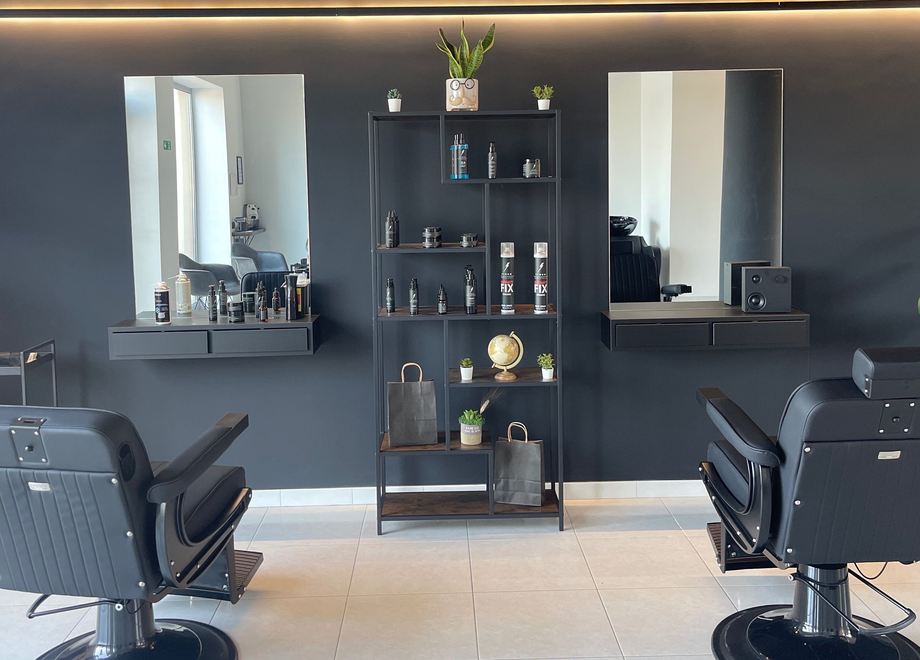 Interno elegante del salone STORM a Capurso, Puglia, IT, con sedie nere e scaffali di prodotti.