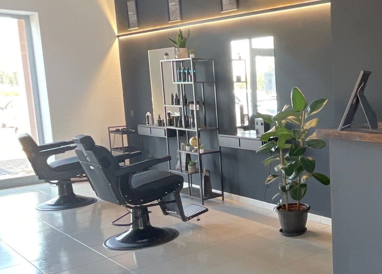 Interno elegante del salone STORM a Capurso, Puglia, IT con sedie da barbiere e piante.
