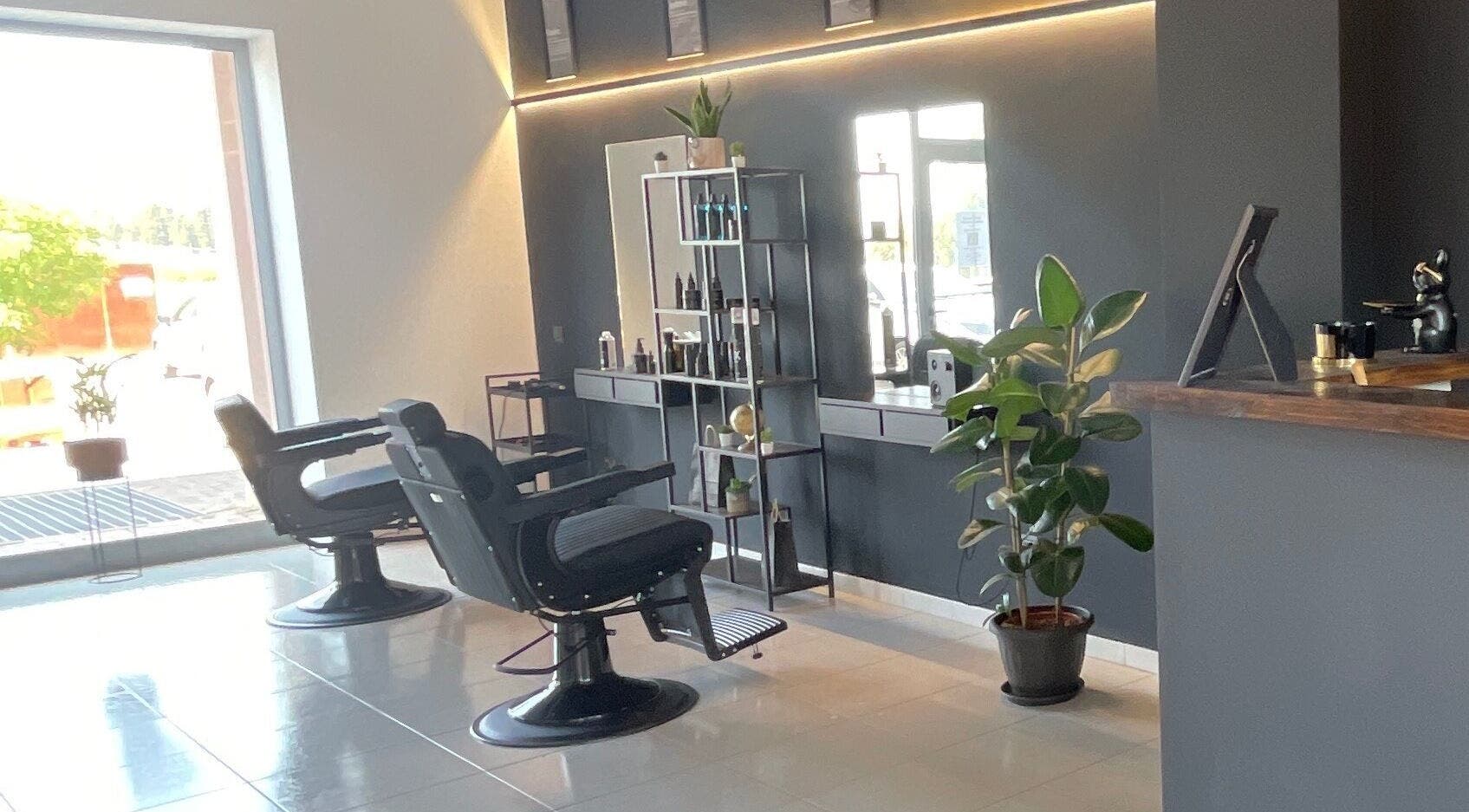 Interno elegante del salone STORM a Capurso, Puglia, IT con sedie da barbiere e piante.