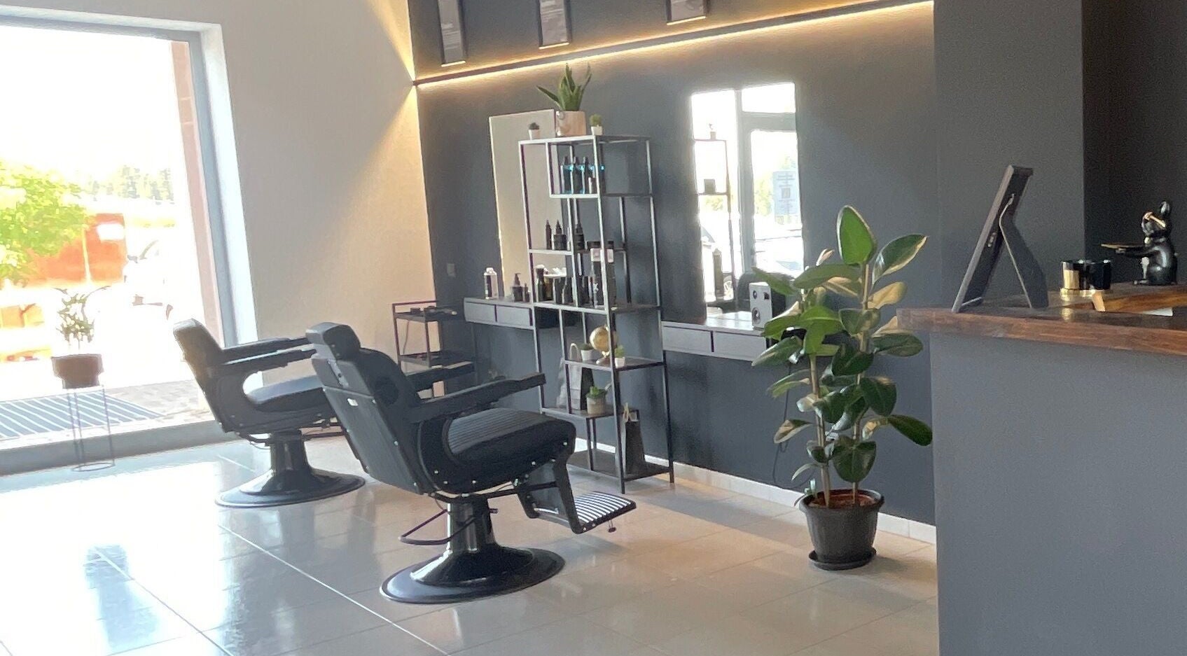 Interno elegante del salone STORM a Capurso, Puglia, IT con sedie da barbiere e piante.