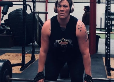 A.S.Sports Therapist client lifting weights with focus at Cramlington, England, GB gym.