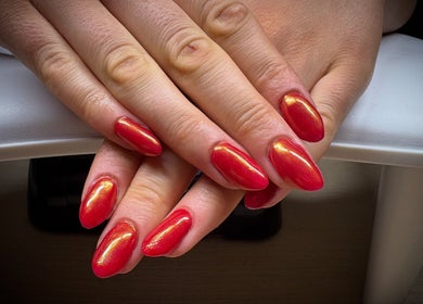 Bright red manicured nails at Nail Envy in Weymouth, England, GB showcasing elegant nail art.