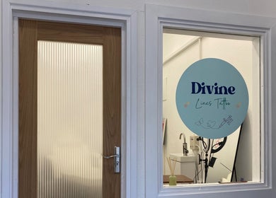 Entrance to Divine Line Tattoo studio in Newquay, England, GB, showing glass door and logo.