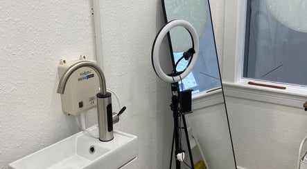 Elegant tattoo studio setup at Divine Line Tattoo, Newquay, England, GB, featuring ring light and mirror.
