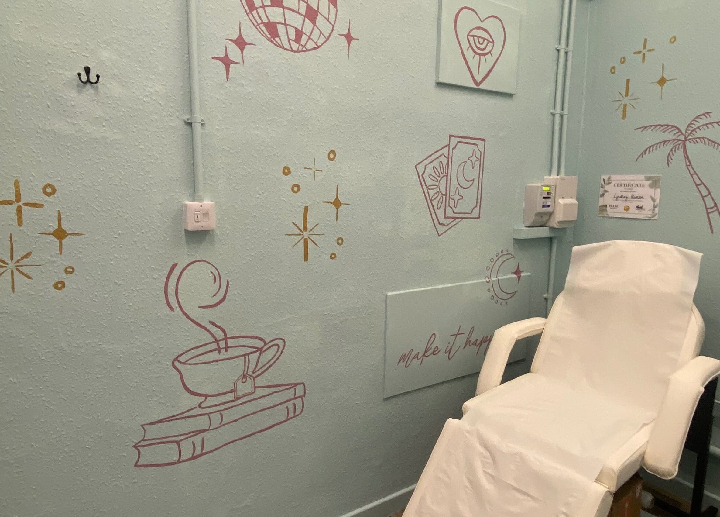 Cozy tattoo room at Divine Line Tattoo in Newquay, England, GB with artistic wall decor and a comfortable chair.