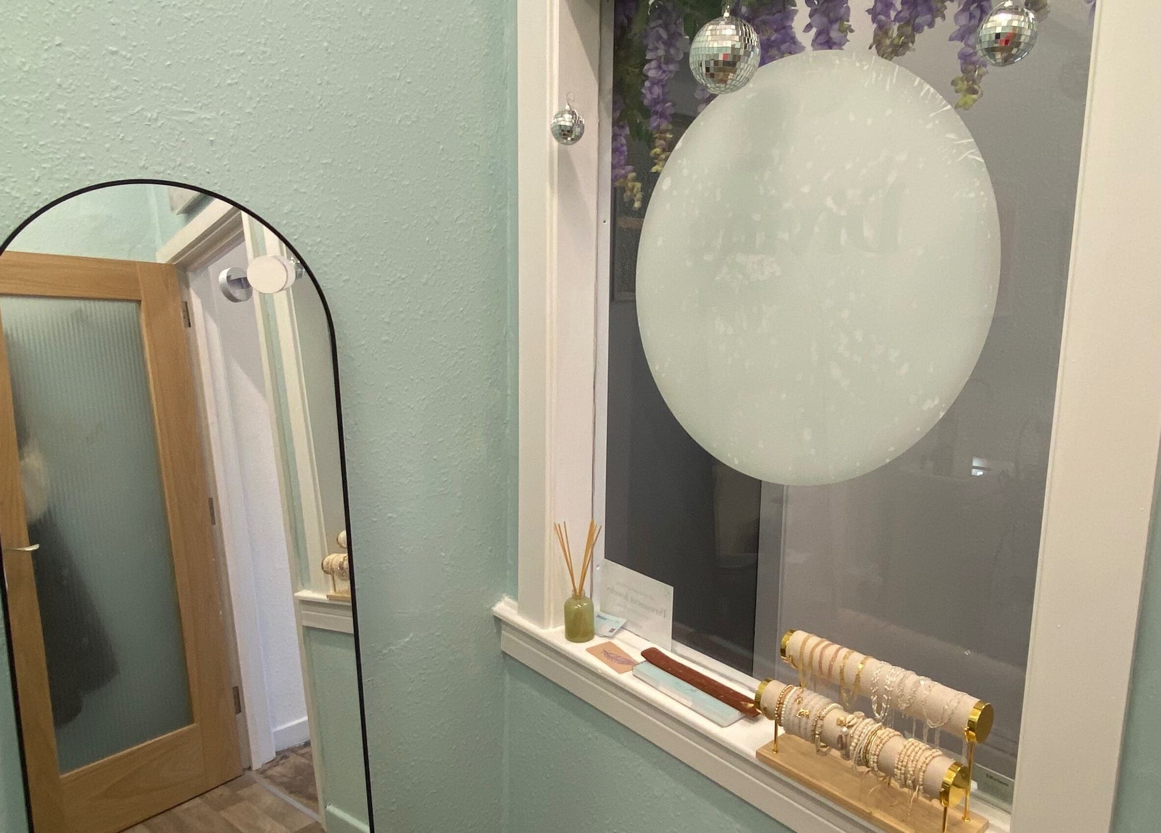 Elegant decor at Divine Line Tattoo in Newquay, England, GB featuring a stylish mirror and bracelets.