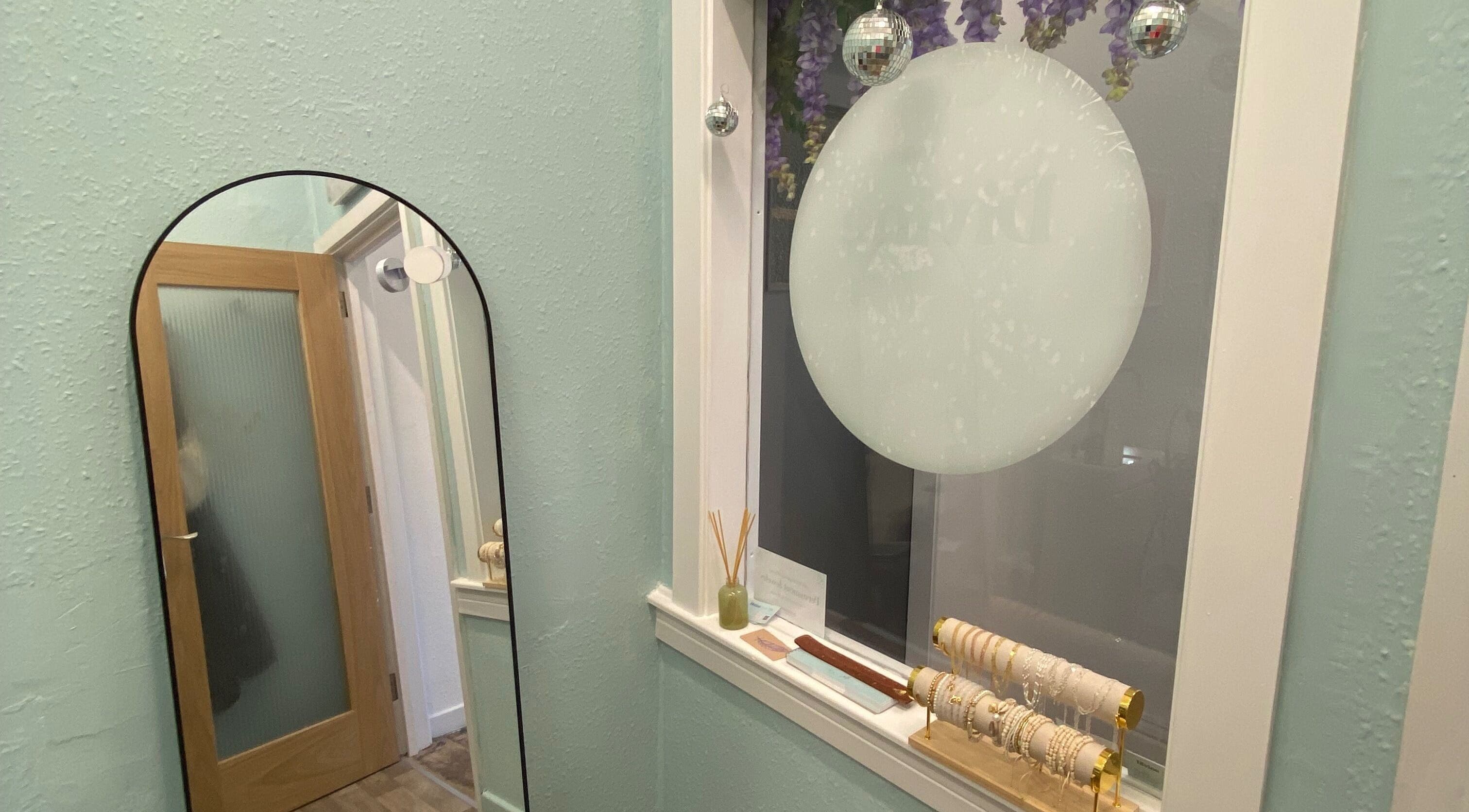 Elegant decor at Divine Line Tattoo in Newquay, England, GB featuring a stylish mirror and bracelets.