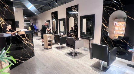 Salón chic de Monalisa Organic Beauty en Barcelona, Catalunya, ES con espejos y estaciones de estilista modernas.