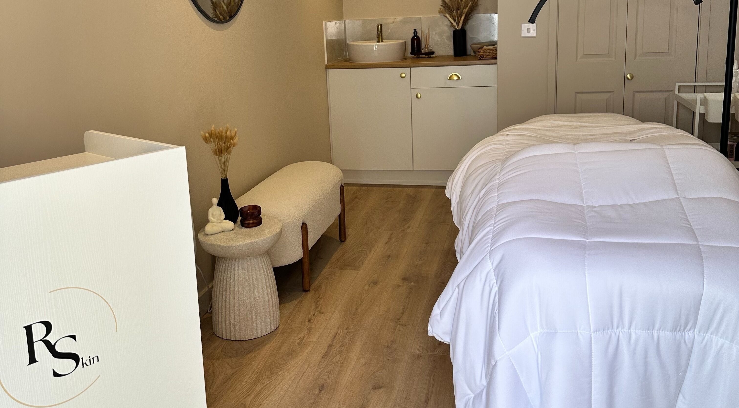 Tranquil treatment room at RS Skin, Dunmow, England with plush bed and stylish decor.