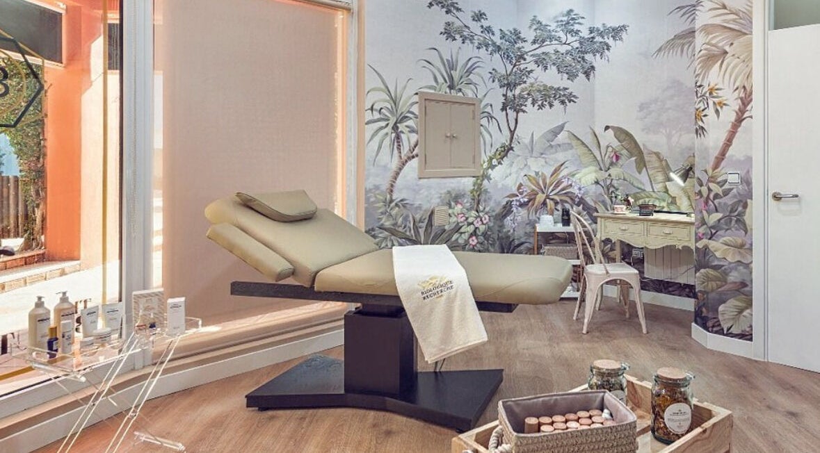 Sala de tratamiento en The Beauty Room, Sotogrande, España, ES, con decoración tropical y cama de masajes.