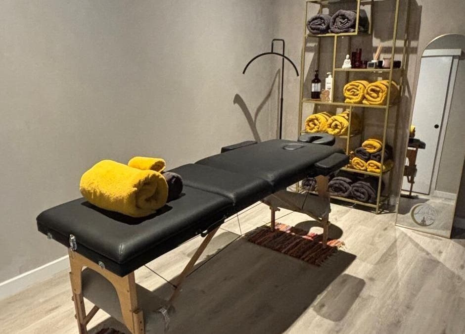 Sala de masaje en Luna Glow, La Roca Del Vallès, Cataluña, ES con camilla y toallas amarillas.