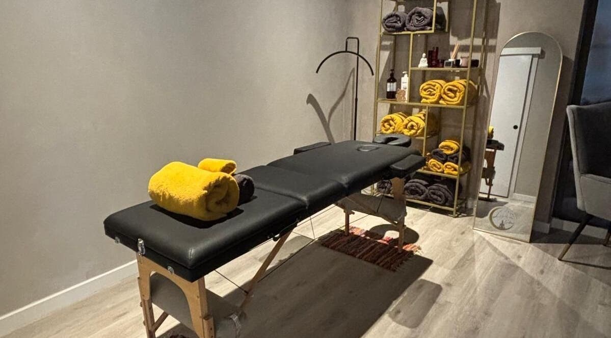 Sala de masaje en Luna Glow, La Roca Del Vallès, Cataluña, ES con camilla y toallas amarillas.
